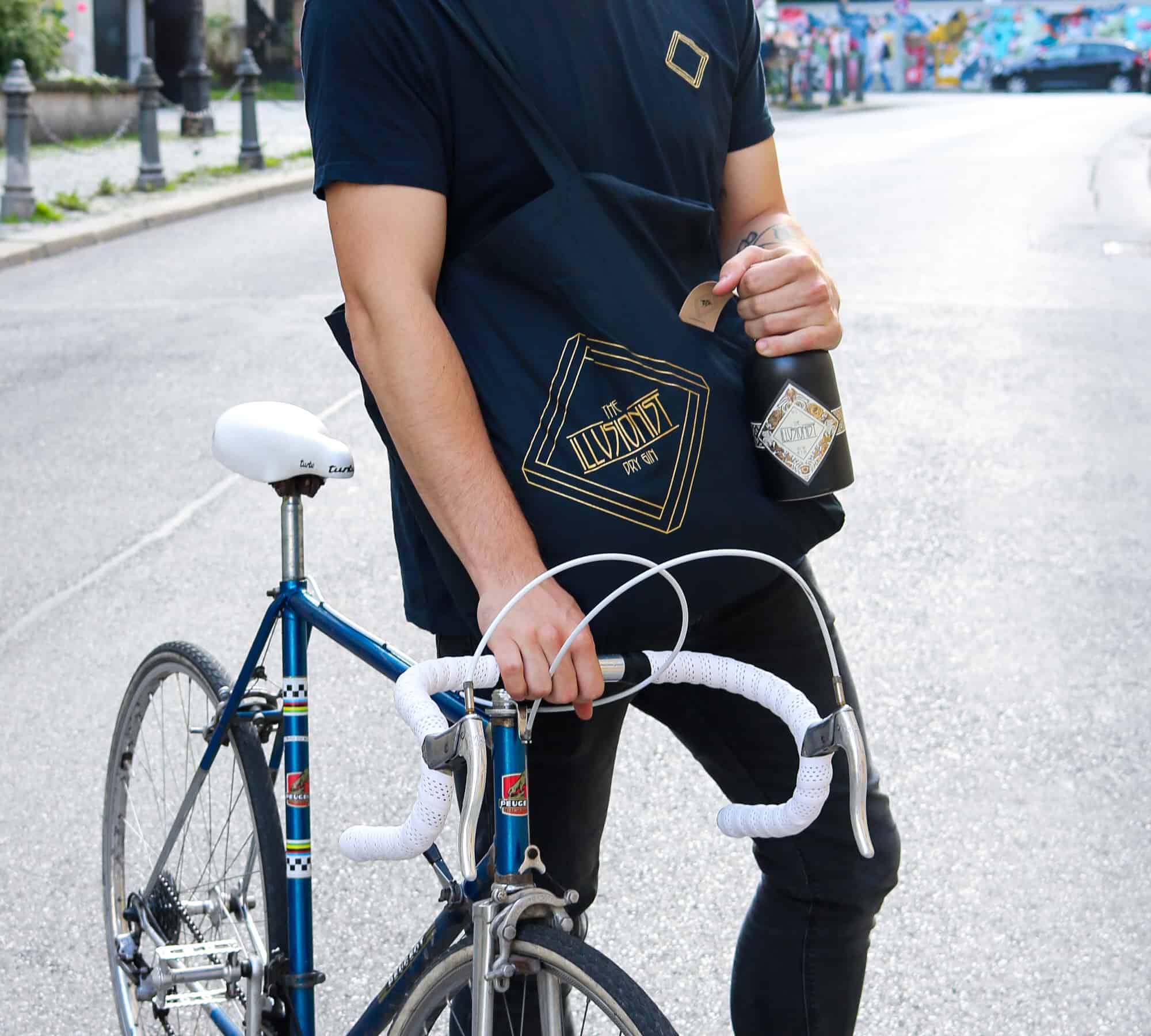 A man carrying the Illusionist Gin Tote Bag while on his bike.