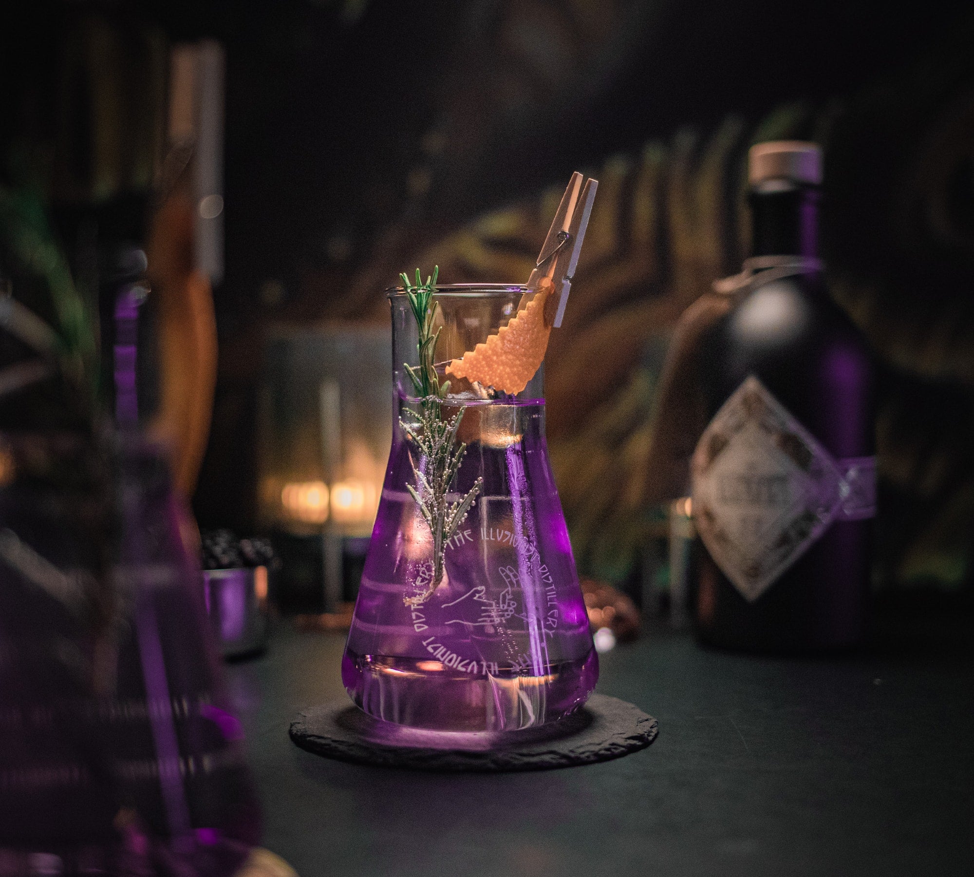 The Illusionist Dry Gin glassware filled up under purple light.